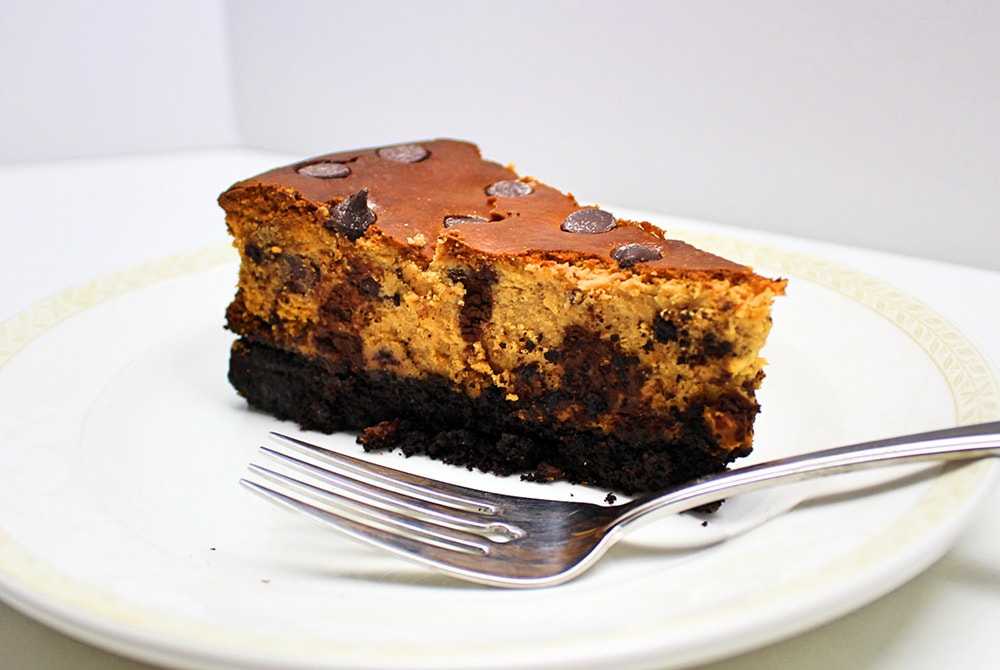 Slice of chocolate chip cheesecake on a white plate.