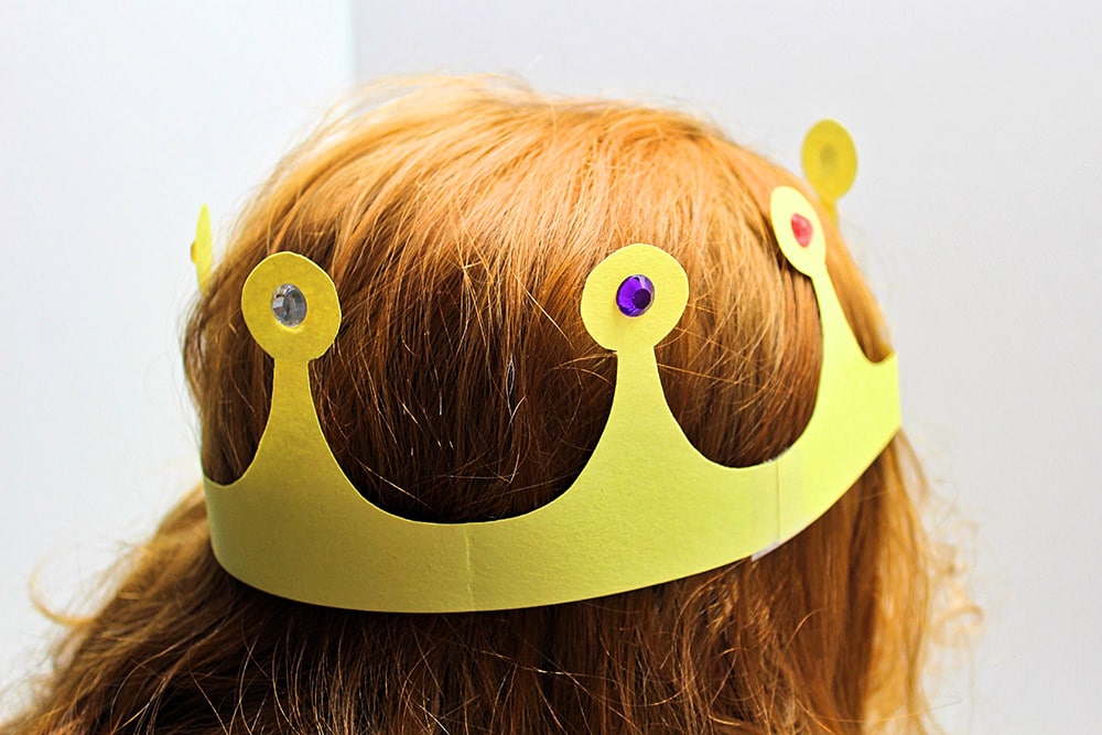 Red-headed child wearing a yellow construction paper crown.