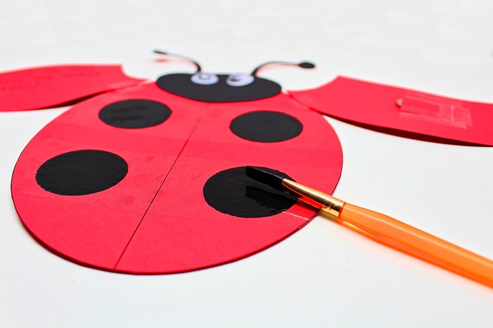 Ladybug card with dots painted with black tape to cover messages.