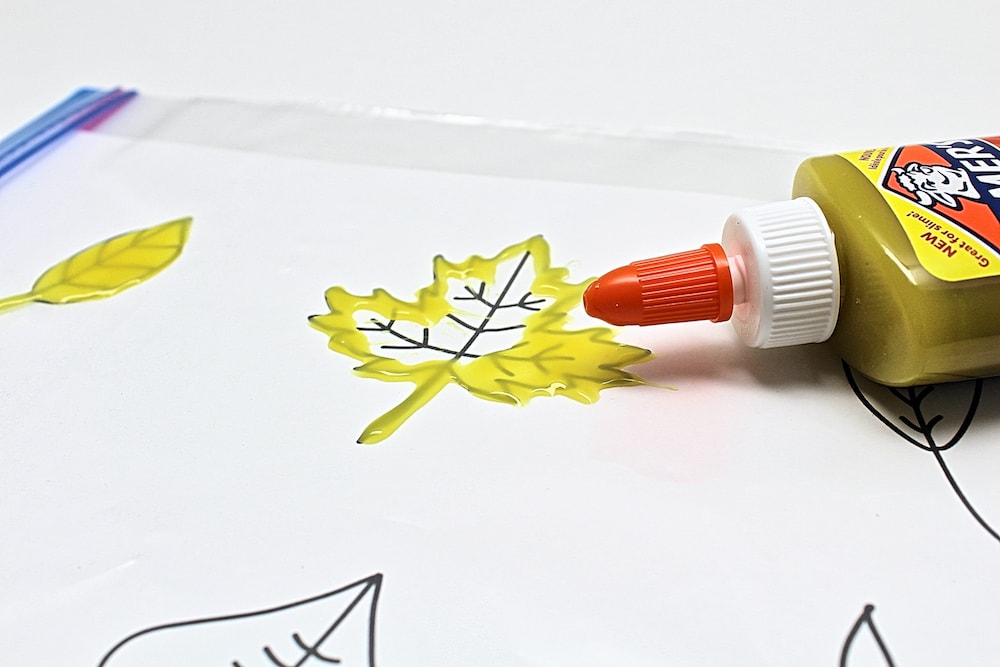 Yellow glue tracing leaves on template.