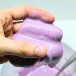 Hand holding up purple slime.
