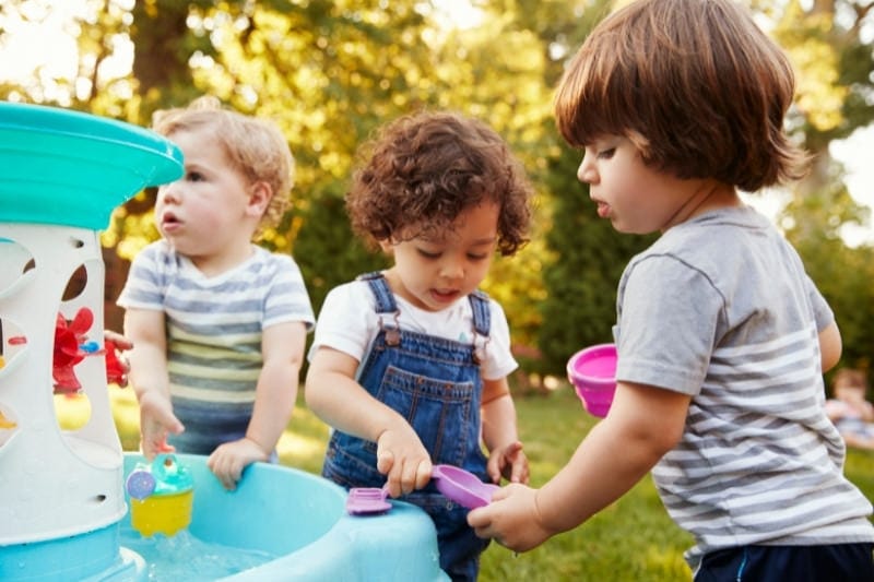Kids playing around a water table.