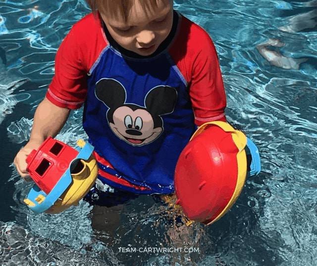 Child in pool with toys.