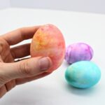 Hand holding Cool Whip dyed Easter egg.