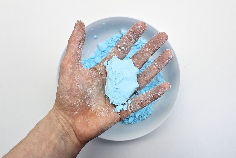 Hand holding ball of foam dough.