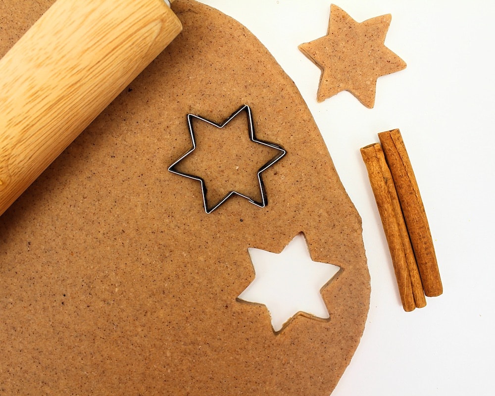 Cinnamon-vanilla play dough rolled out with star-shaped cookie cutter