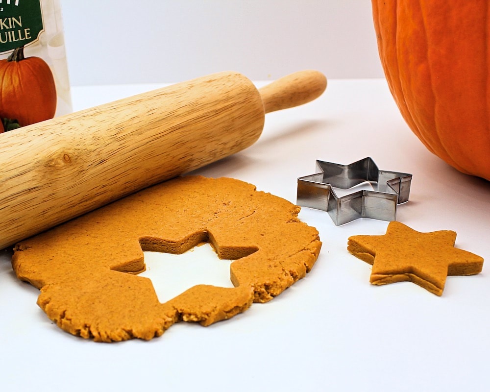 Pumpkin play dough flattened with rolling pin, with star-shaped hole from a cookie cutter