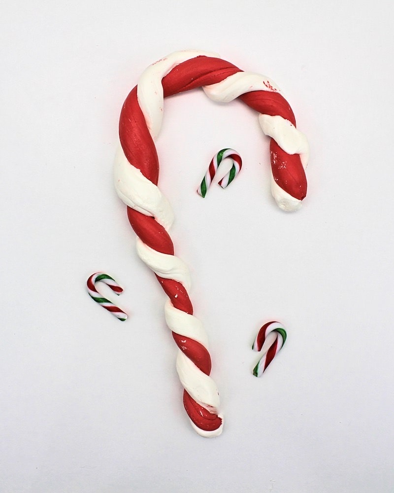Edible candy cane slime twisted into the shape of a candy cane.