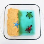 Ocean sensory bin with ground-up Cheerio sand.