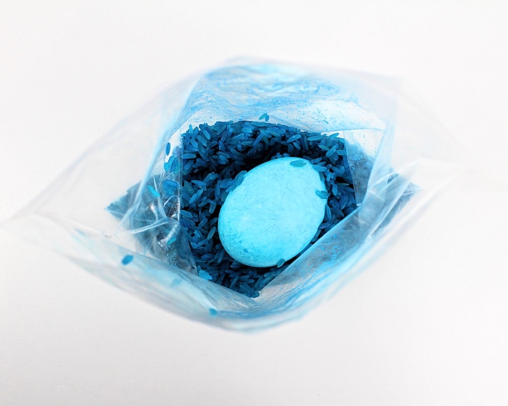 Dyed egg inside a bag of blue rice.