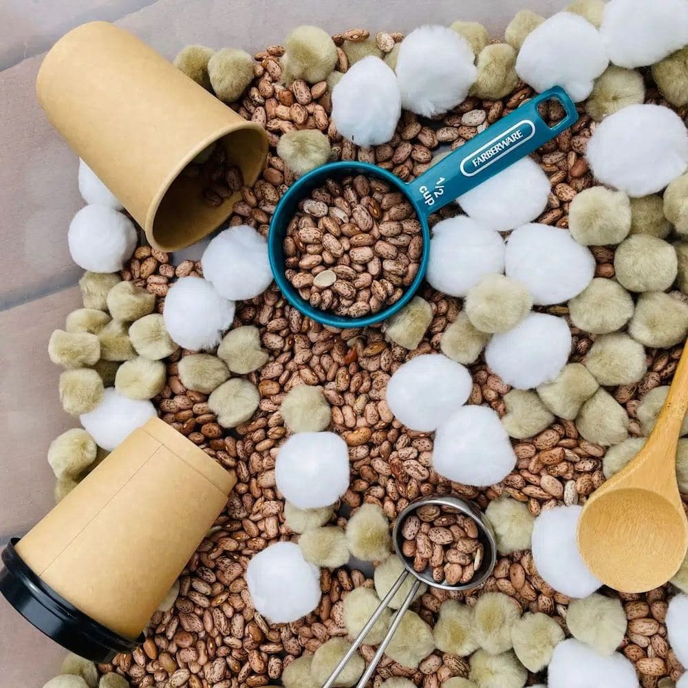 Bin filled with brown dried beans and cotton balls.