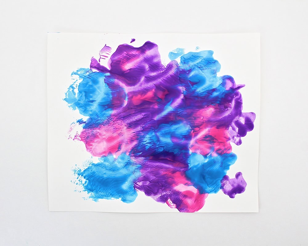 Sheet of white cardstock covered with pink, purple and blue paint.