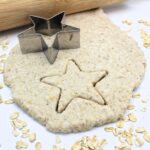 Oatmeal play dough, flattened by a rolling pin and cut with a star-shaped cookie cutter.