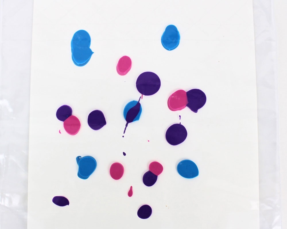 Sealed bag containing a sheet of white cardstock covered with blobs of paint.