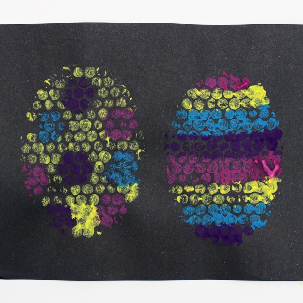 Bubble wrap painted Easter eggs on black construction paper.