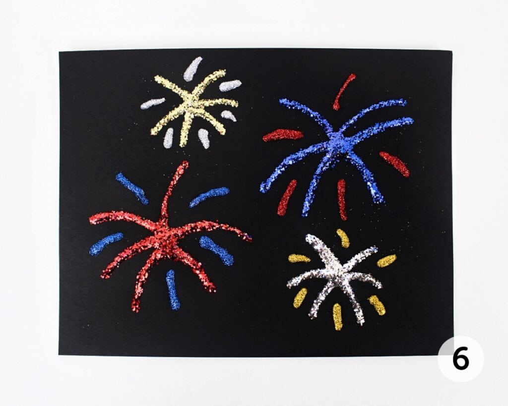 Finished glitter fireworks craft with excess glitter removed.