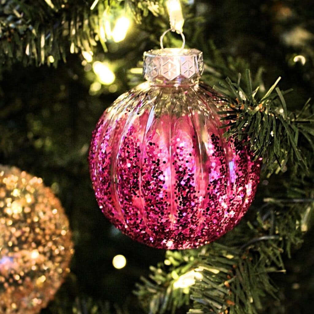Glittery ornament hanging on a Christmas tree.