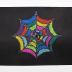 Colorful spiderweb craft on black paper.