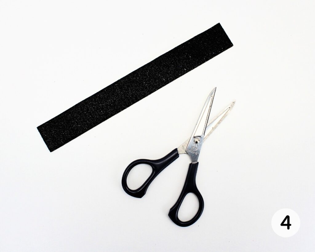 Strip of black foam cut with scissors.