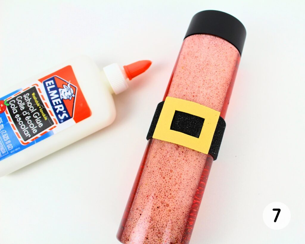 Red glitter bottle with yellow belt buckle glued to the black belt.