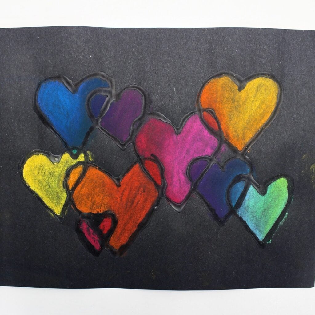Colorful overlapping heart craft on black paper.