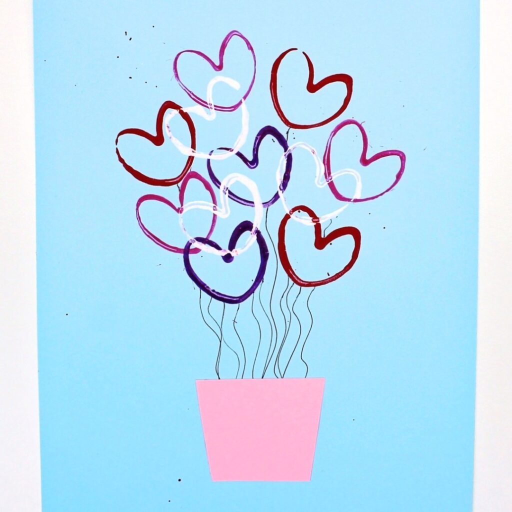 Hot air balloon craft made with DIY toilet paper roll heart stamps.