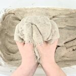 Hands holding up fluffy gray foam.