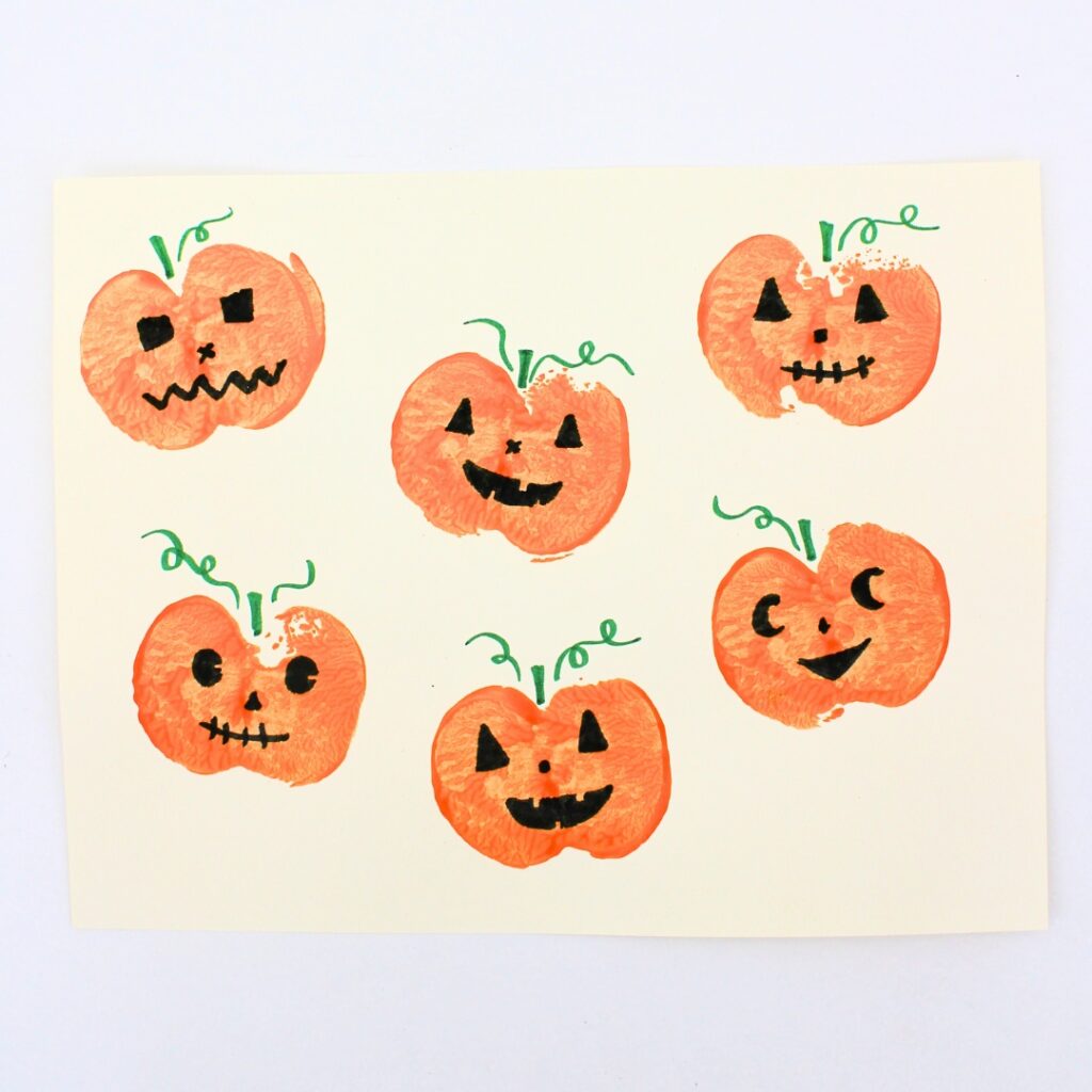 Jack-o'-lantern craft with pumpkins stamped using apples.