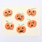 Jack-o'-lantern craft with pumpkins stamped using apples.