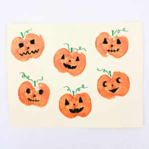 Jack-o'-lantern craft with pumpkins stamped using apples.