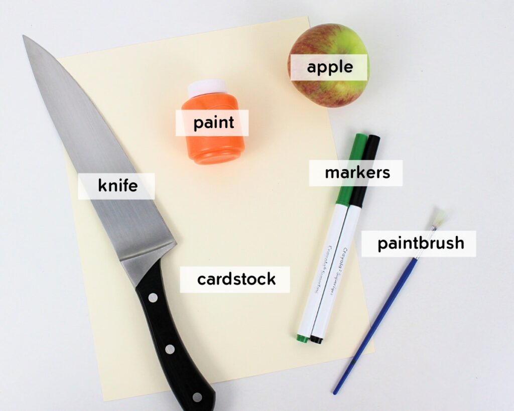 Supplies to make apple stamped jack-o'-lanterns.