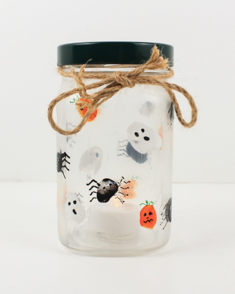 Finished candle holder with fingerprint ghosts, spiders and jack-o'-lanterns.