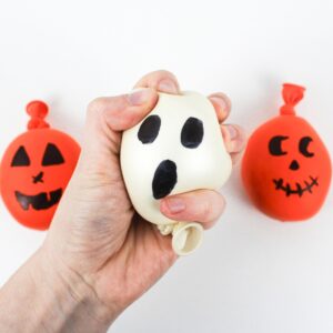 2 jack-o'-lantern stress balls with a hand squishing a ghost stress ball.
