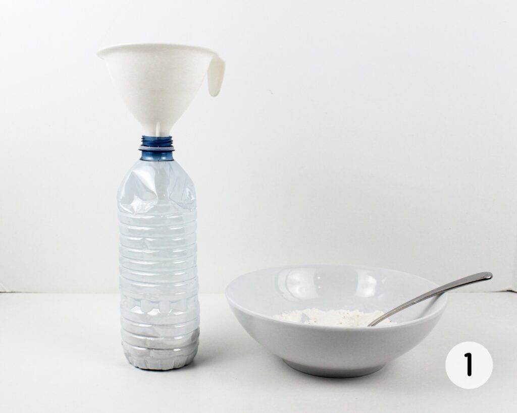 Flour falling into an empty plastic water bottle through a funnel.
