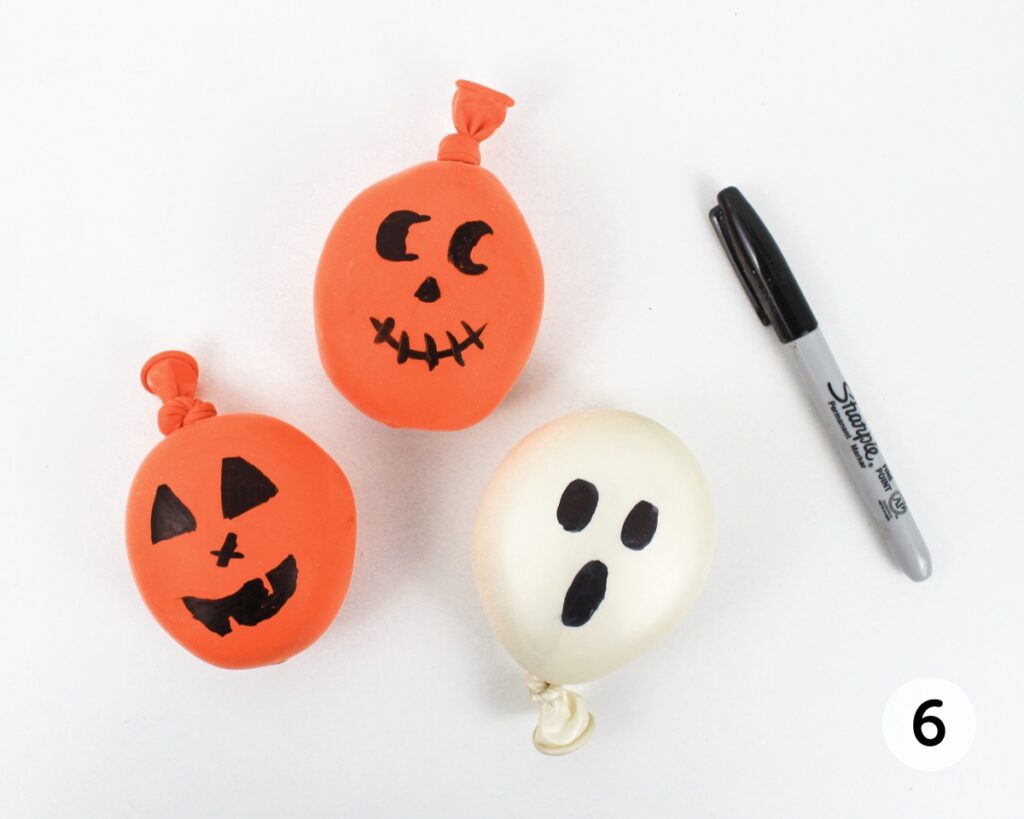 Jack-o'-lantern and ghost balloon stress balls, with a permanent marker.