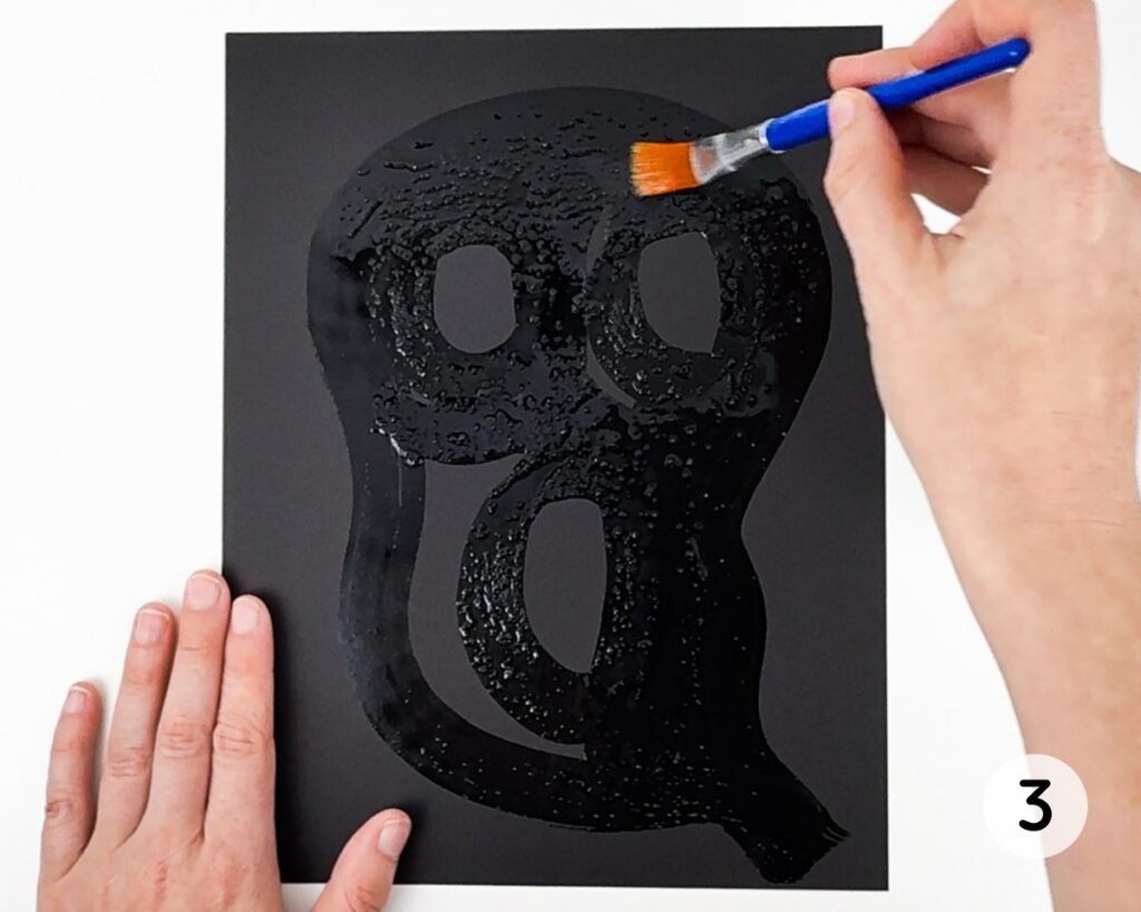 Black cardstock with ghost painted with salt water.