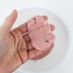 Hand holding oozing pink slime.