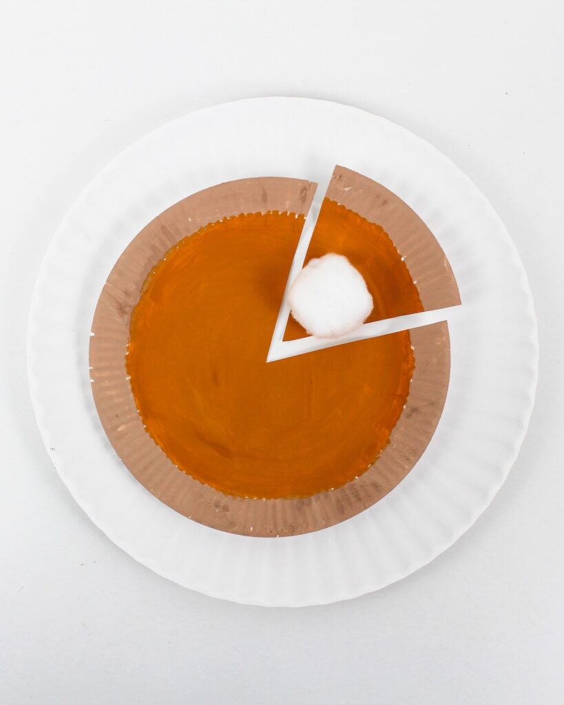Finished paper plate pumpkin pie craft with cotton ball whipped cream.