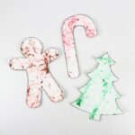 Gingerbread man, candy cane and Christmas tree crafts with marbled patterns.