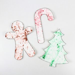 Gingerbread man, candy cane and Christmas tree crafts with marbled patterns.