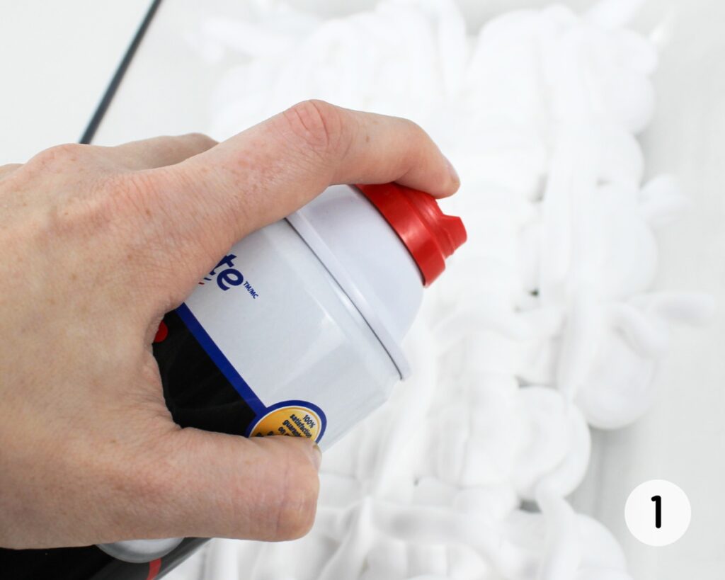 Hand spraying shaving foam into a glass dish.