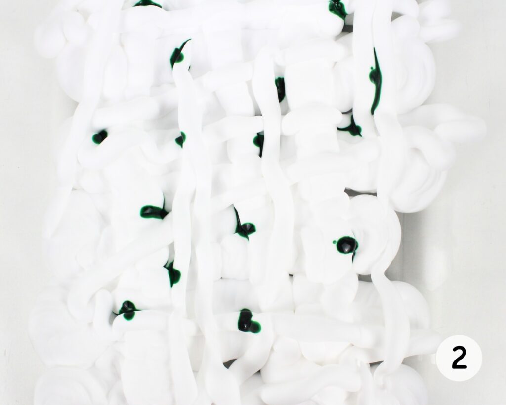 Shaving cream with dots of green food coloring.