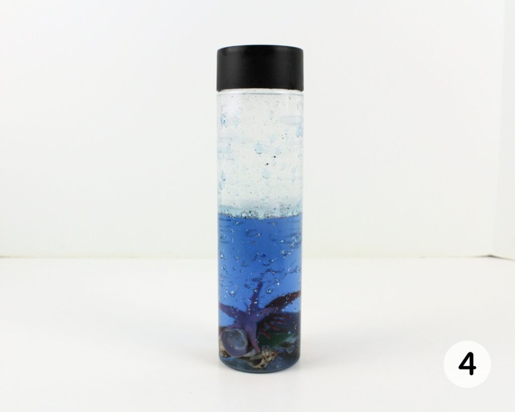 Finished ocean sensory bottle with baby oil up to the top.