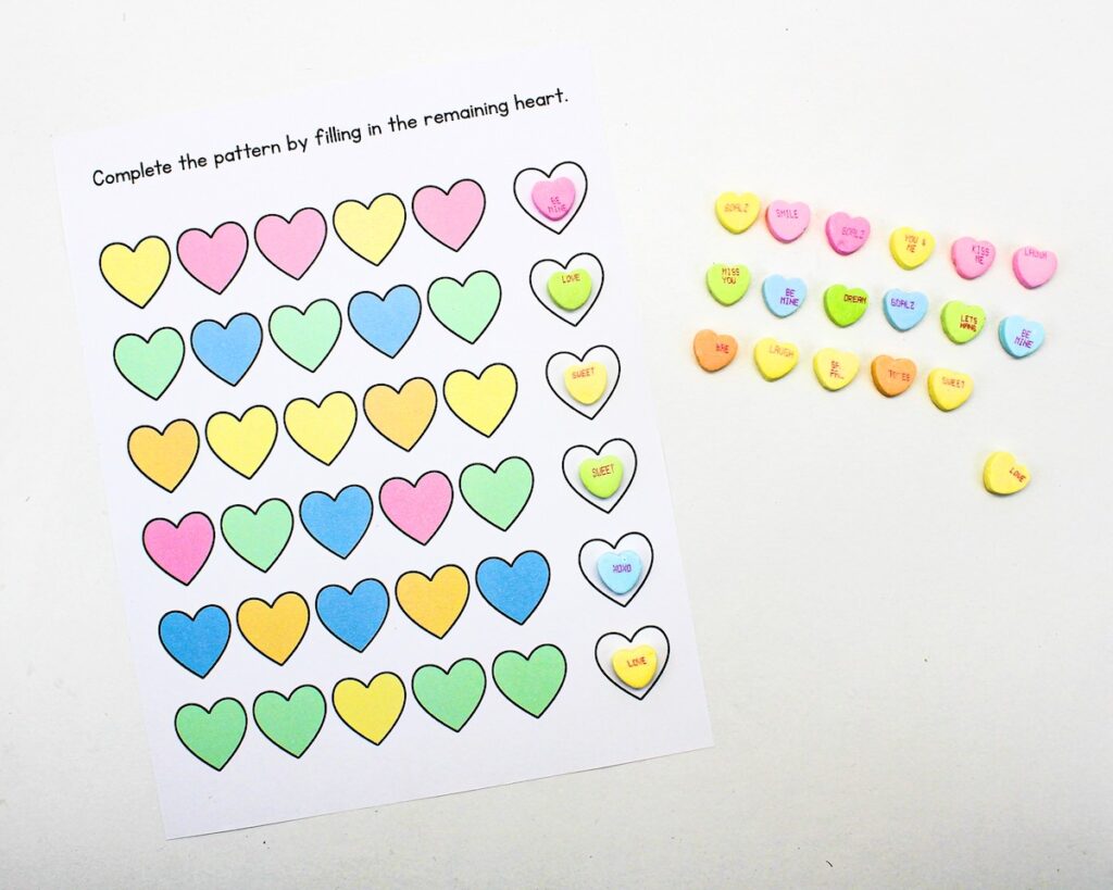 Printed heart pattern worksheet with conversation heart candies arranged in patterns.