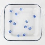 Floating blue snowflake drawings inside a glass dish with water.