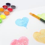 Painted blue heart craft with the words "be mine" appearing in white under the paint.