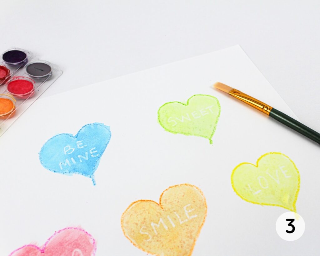 Painted hearts with the white words appearing under the paint.