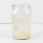 Heart candies floating up in a jar of water.