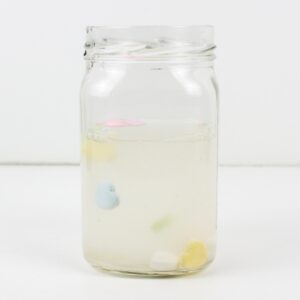 Heart candies floating up in a jar of water.