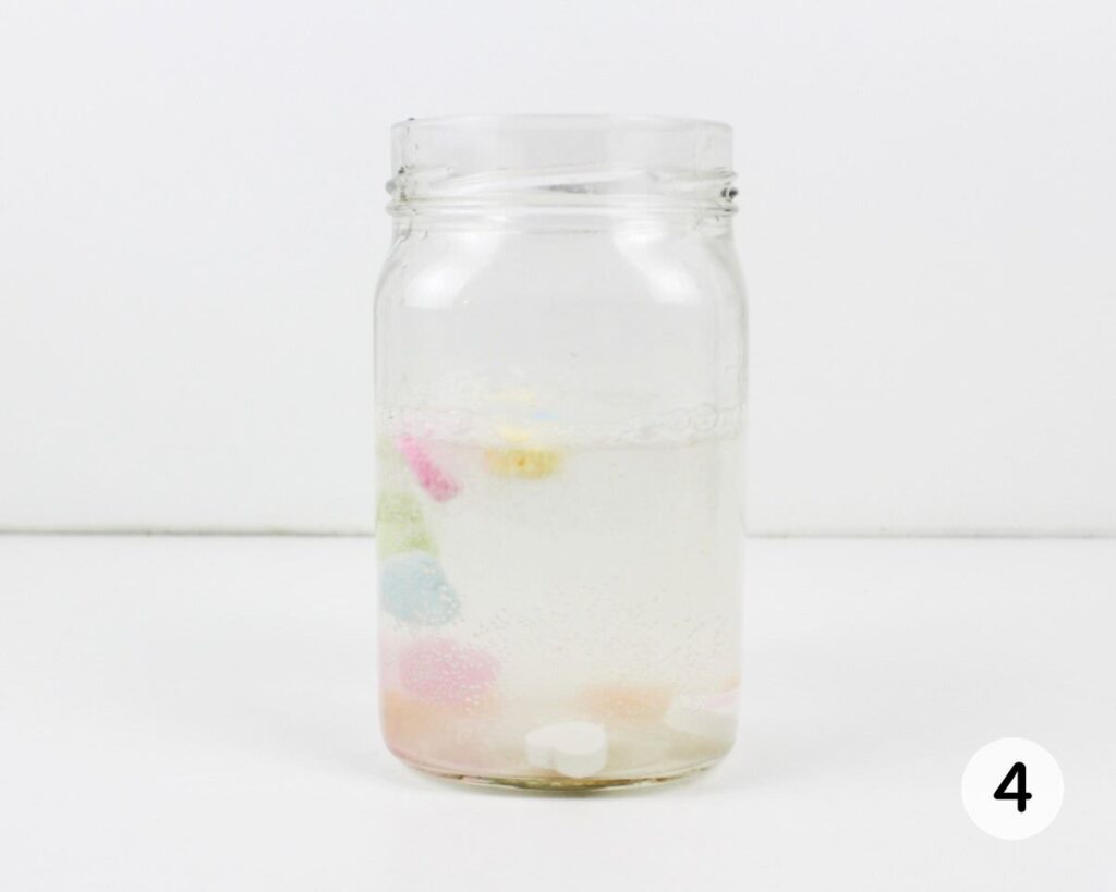 Conversation heart candies floating up in a jar of water.